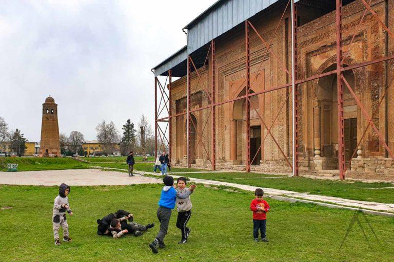 uzgen kids playing next to minaret and mausoleum