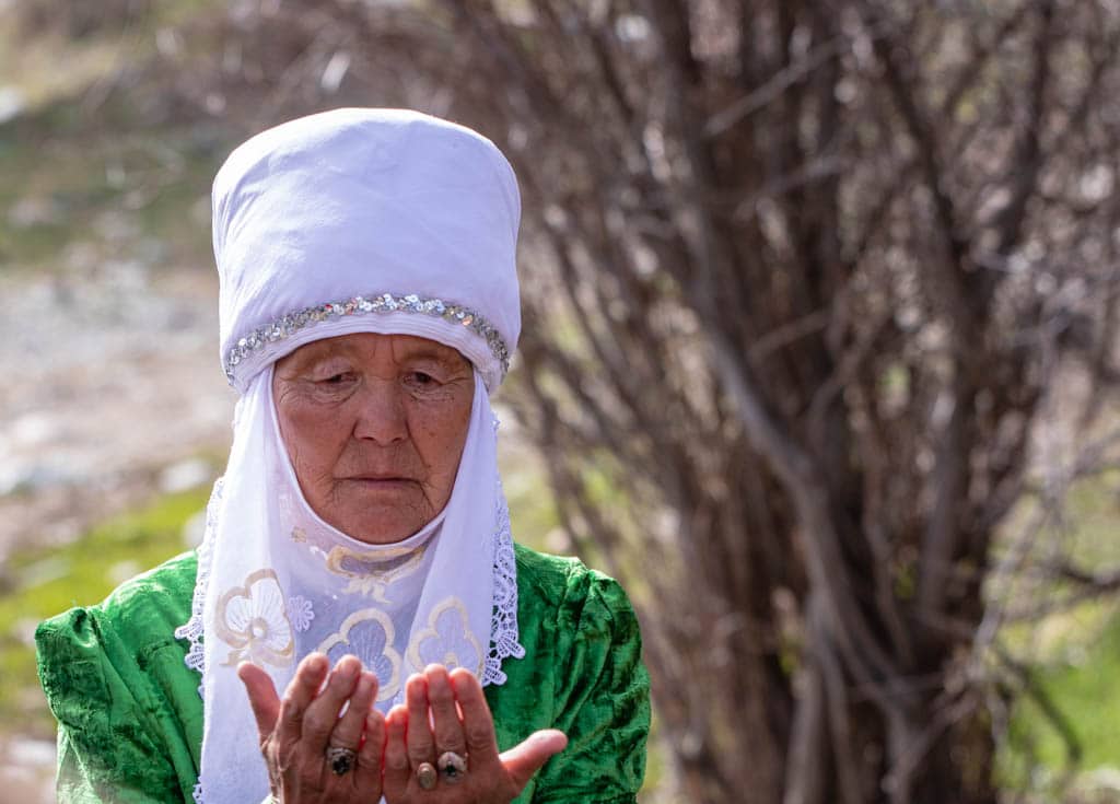 Old woman wearing traditional Kyrgyz clothes and elechek