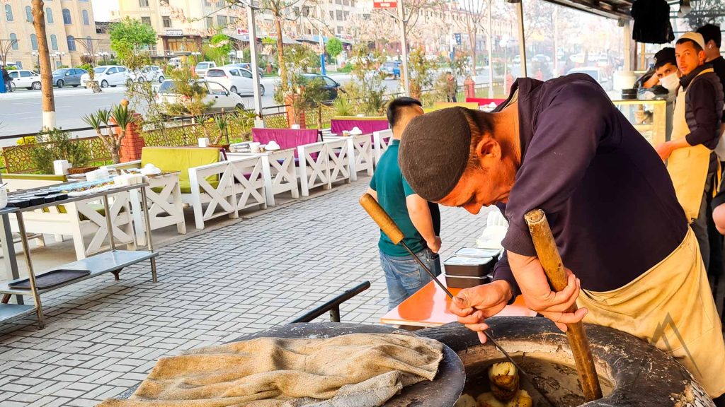 men preparing uzbek samsy in the tandyr