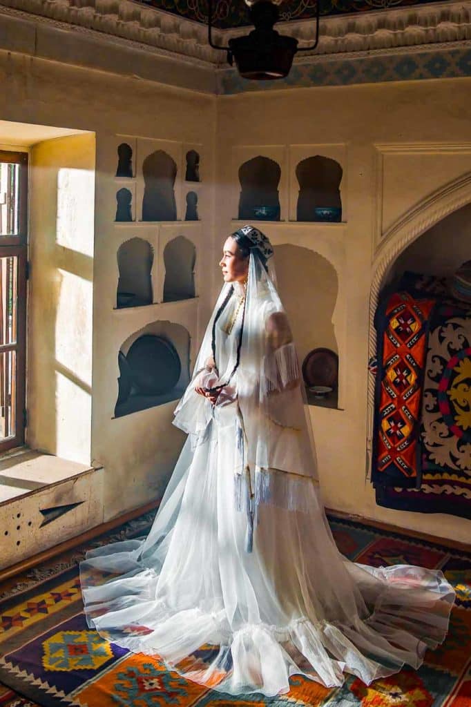 Una donna uzbeka che indossa un abito da sposa bianco