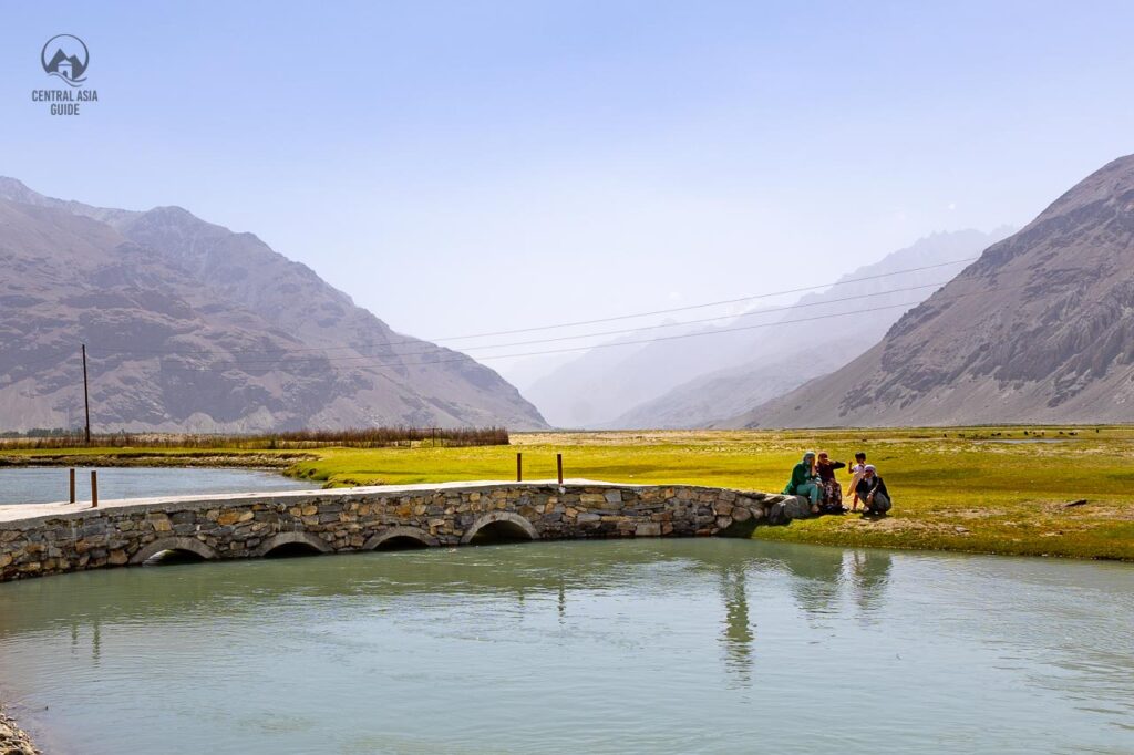 Pamiri women taking care of children by the Panj river in Wakhan Valley