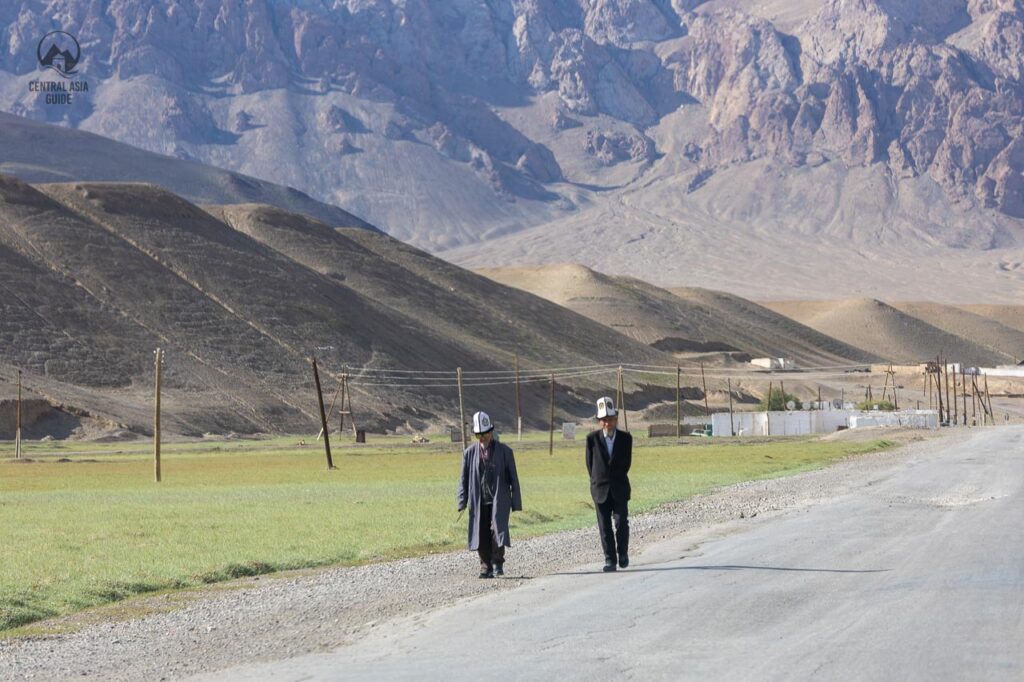 Old Kyrgyz men walking in Murghab, Pamir wearing traditional Kalpak