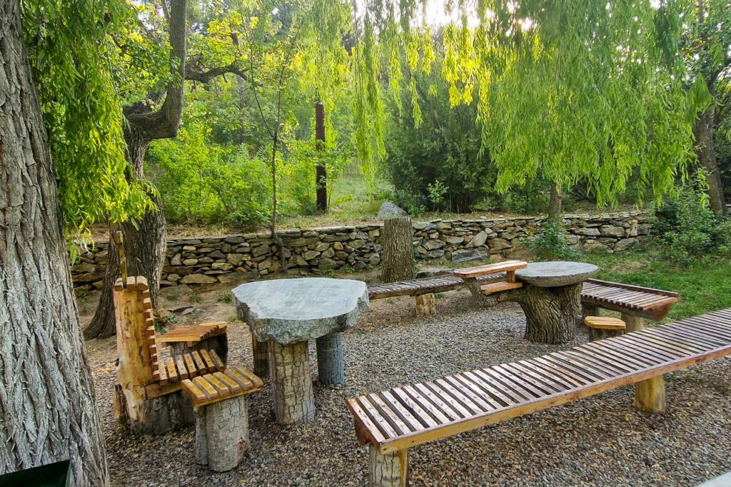 Picnic table under trees in the Khorog botanical garden