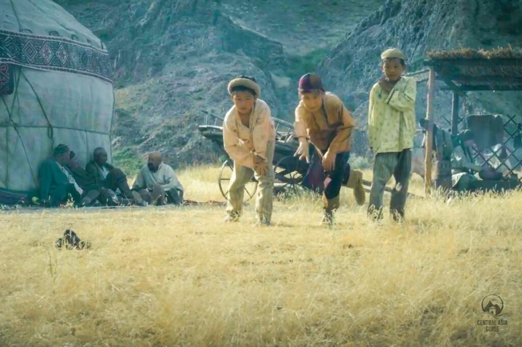 Children throwing the traditional Kazakh game, Asyk Atu, bones on a field