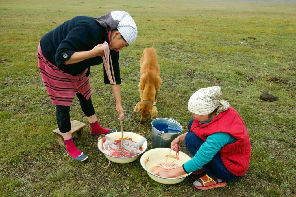 Preparing traditional Kyrgyz food from the intestines of an animal.