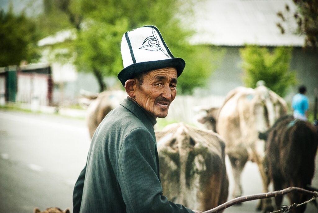 Uomo kirghiso che indossa il kalpak, il tradizionale cappello bianco da uomo in Kirghizistan