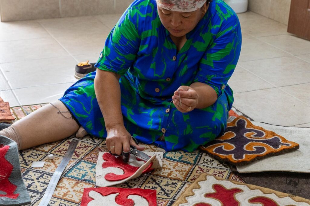 Kyrgyz woman working on shyrdak oriental patterns